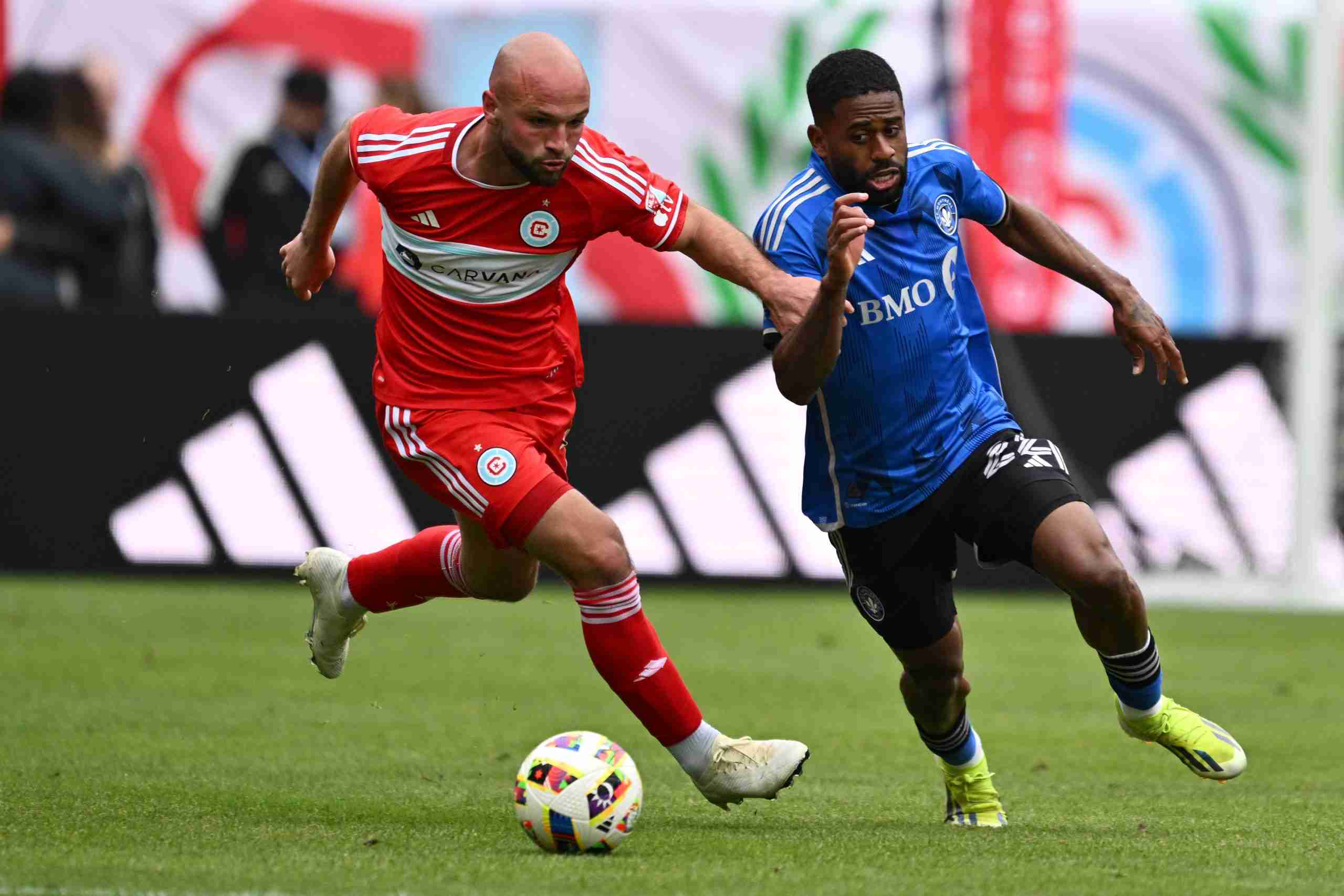 Mar 16, 2024; Chicago, Illinois, USA;Chicago Fire FC defender Chase Gasper (77) and CF Montreal defender Ruan (22) battle for the ball during the first half at Soldier Field. Mandatory Credit: 