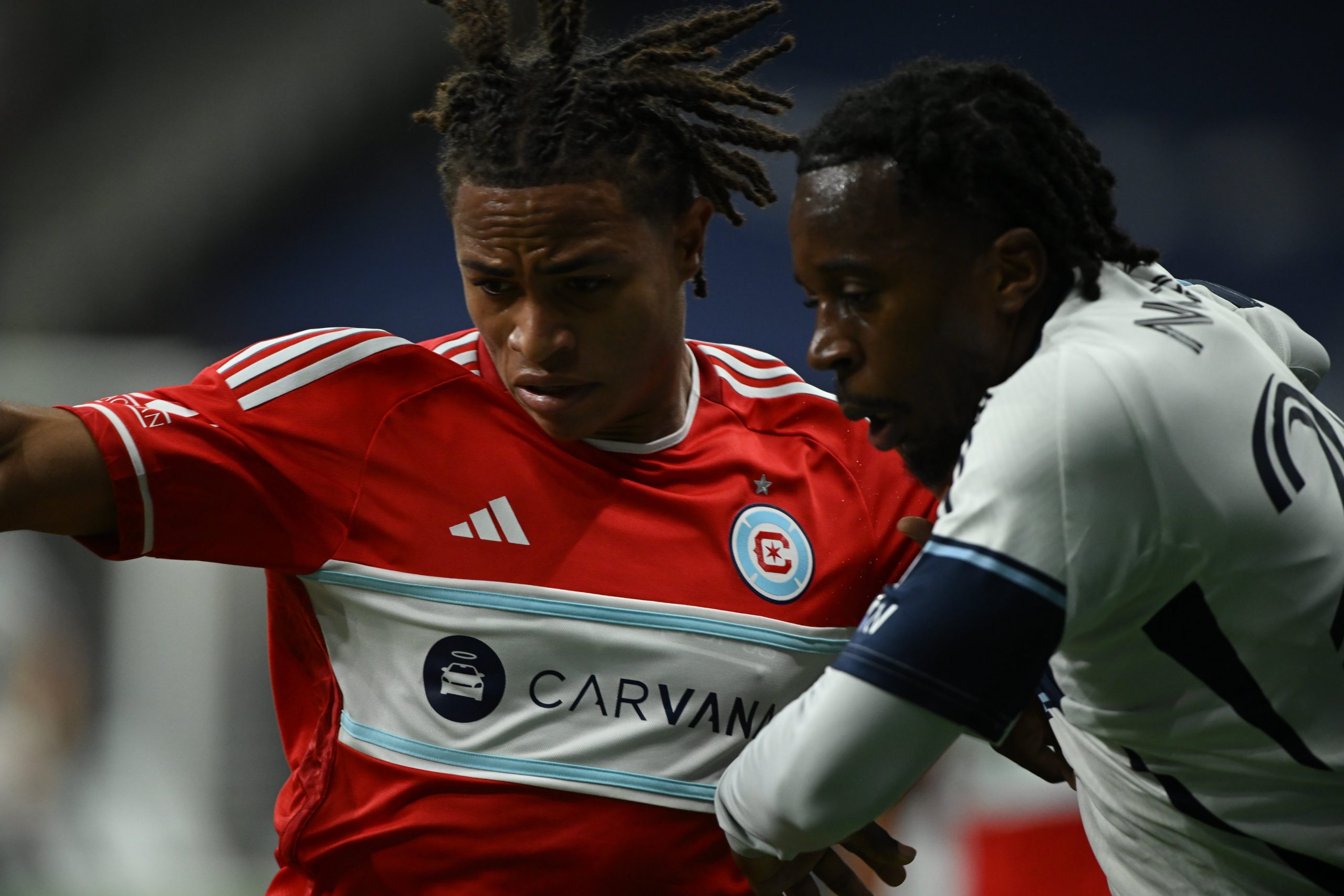 Mar 22, 2025; Vancouver, British Columbia, CAN;Chicago Fire FC defender Leonardo Barroso (2) battles for the ball against Vancouver Whitecaps FC midfielder Jean-Claude Ngando (26) during the first half at BC Place. Mandatory Credit: Anne-Marie Sorvin-Imagn Images