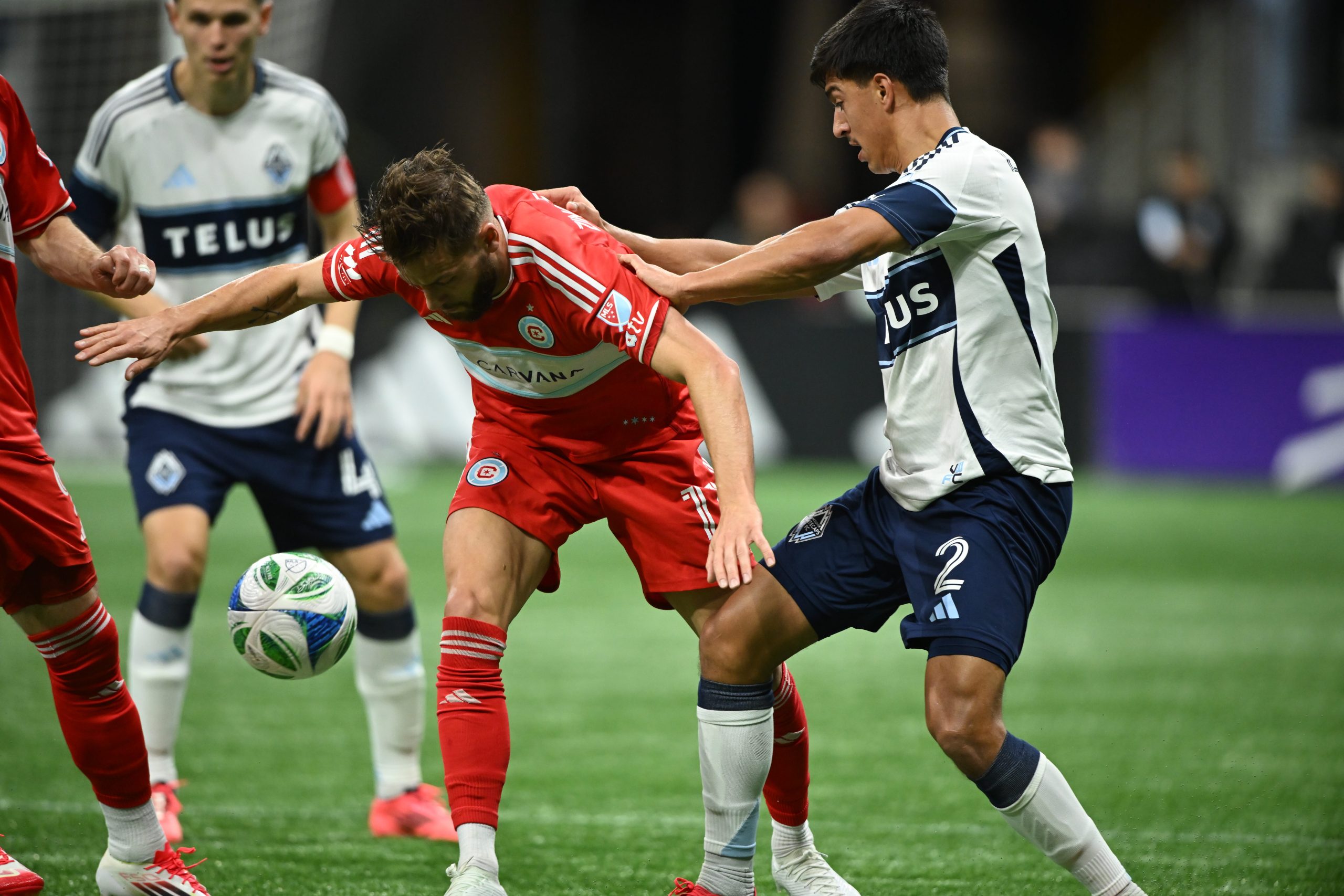 Mar 22, 2025; Vancouver, British Columbia, CAN; Chicago Fire FC forward Philip Zinckernagel (11) battles for the ball against Vancouver Whitecaps FC defender Mathias Laborda (2) during the first half at BC Place. Mandatory Credit: Anne-Marie Sorvin-Imagn Images