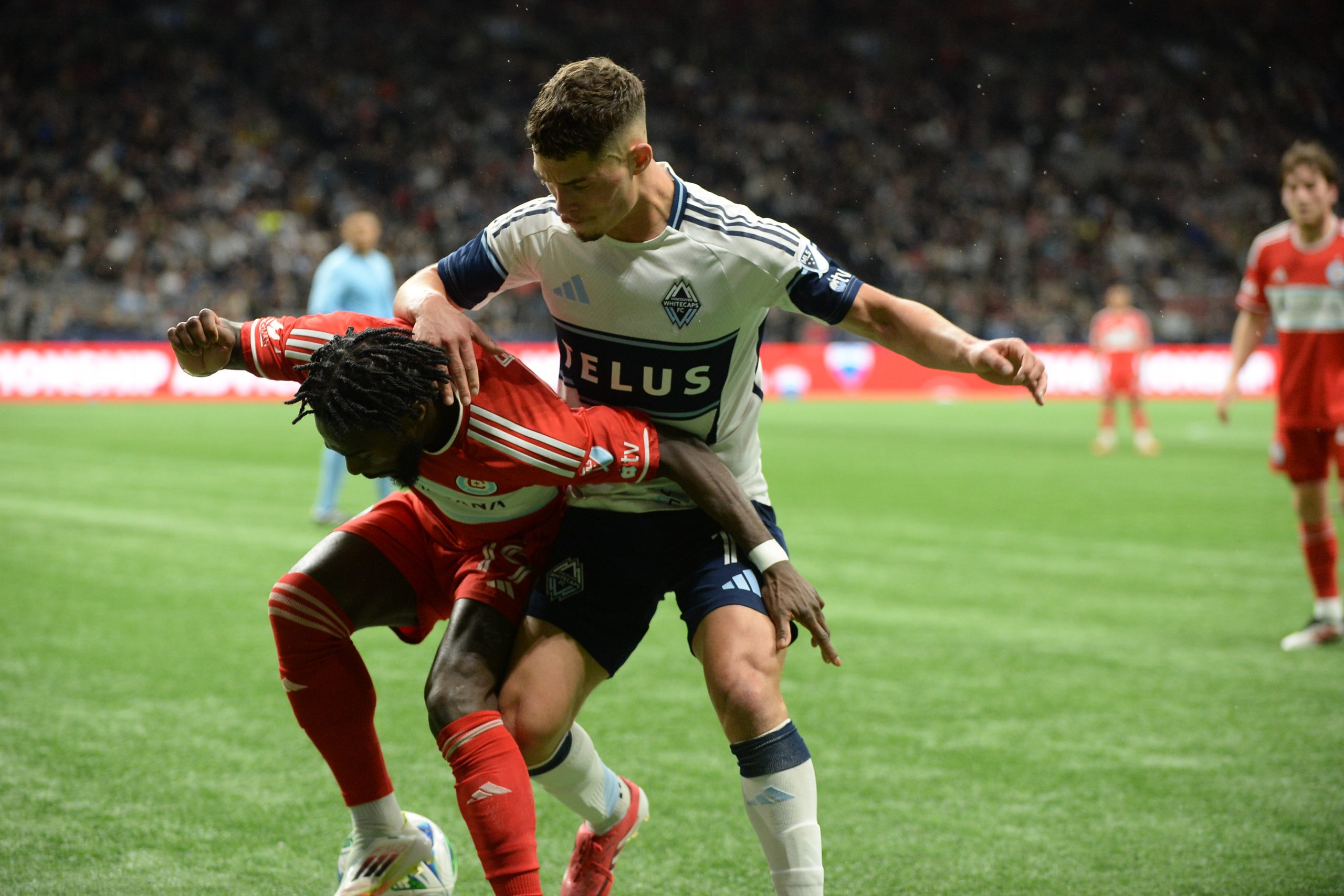 Mar 22, 2025; Vancouver, British Columbia, CAN;  Chicago Fire FC forward Jonathan Bamba (19) battles for the ball against Vancouver Whitecaps FC midfielder Sebastian Berhalter (16) during the second half at BC Place. Mandatory Credit: Anne-Marie Sorvin-Imagn Images