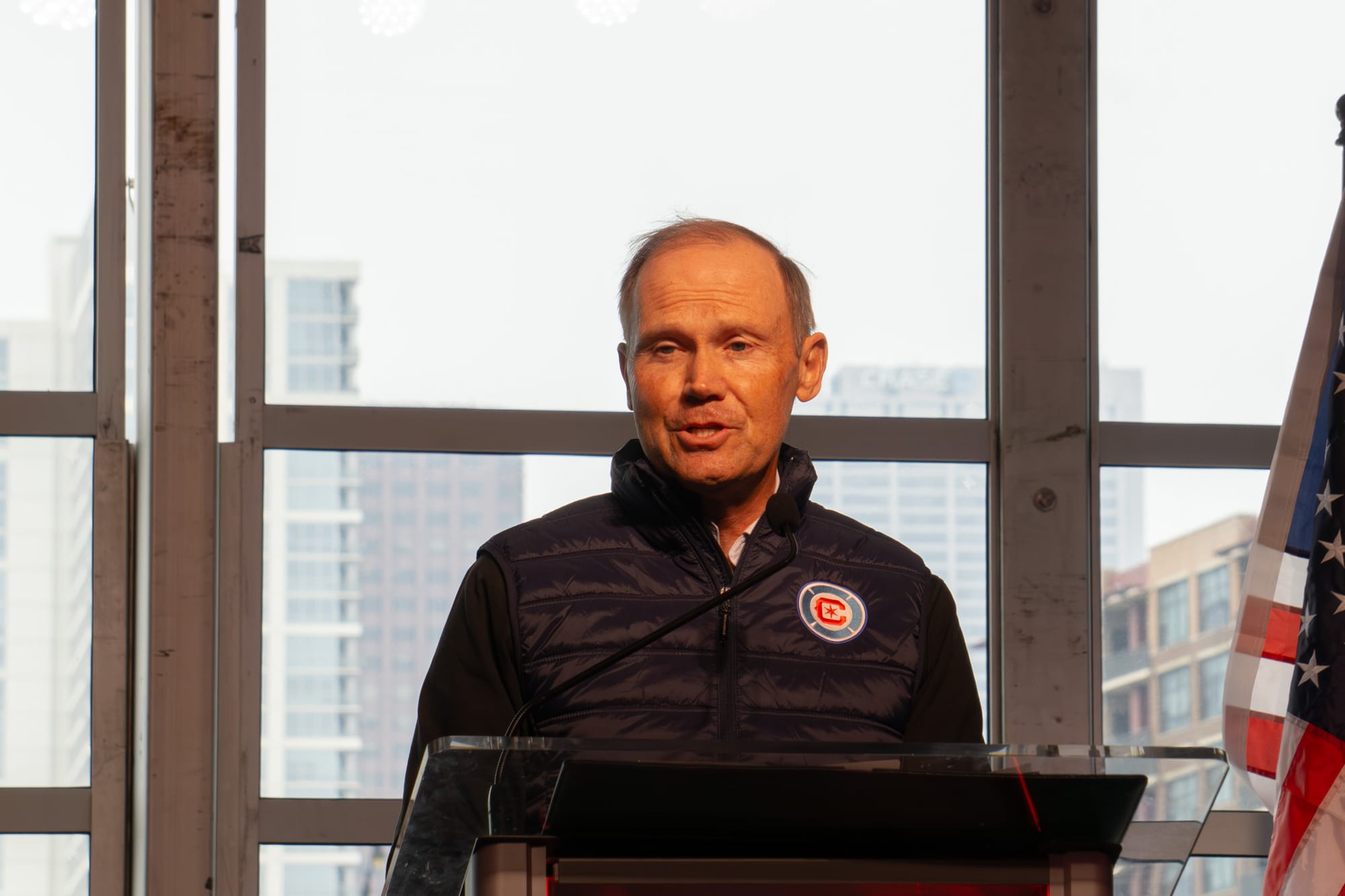 Joe Mansueto standing in front of a podium with midrises in the background