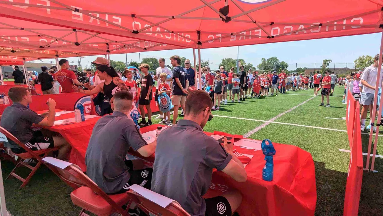 Fans gather to meet players signing autographs under tents
